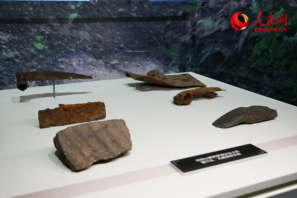 鸡冠山簸箕掌遗址出土的镰刀头、石磨盘等农具。人民网记者 韦衍行摄
