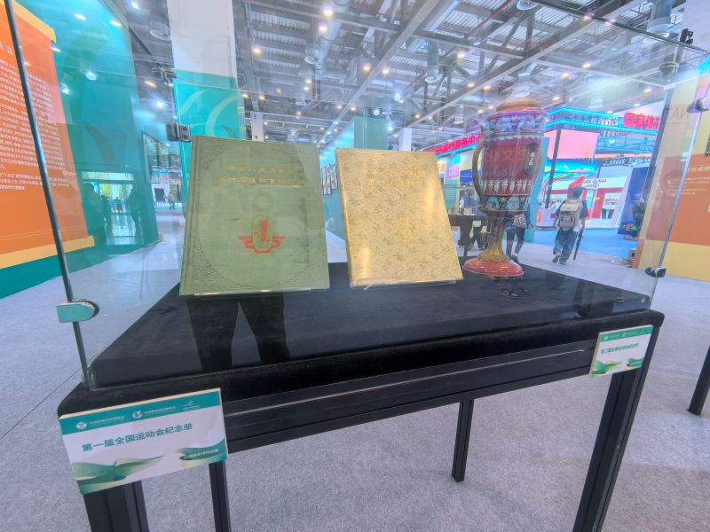 体育文化主题展区里第一届全国运动会纪念册展品。人民网记者 杨磊摄