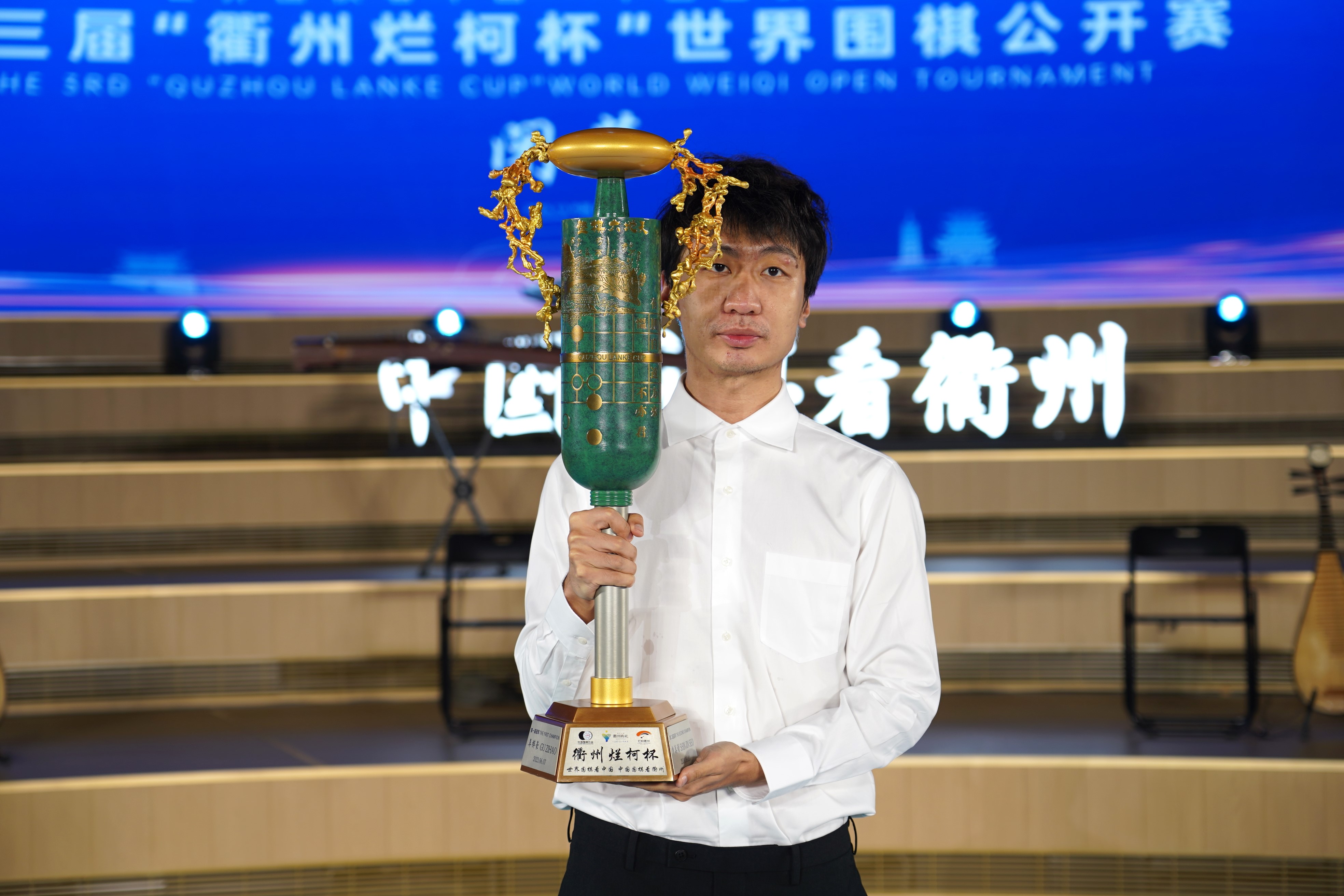 党毅飞捧起冠军奖杯。中国围棋协会供图