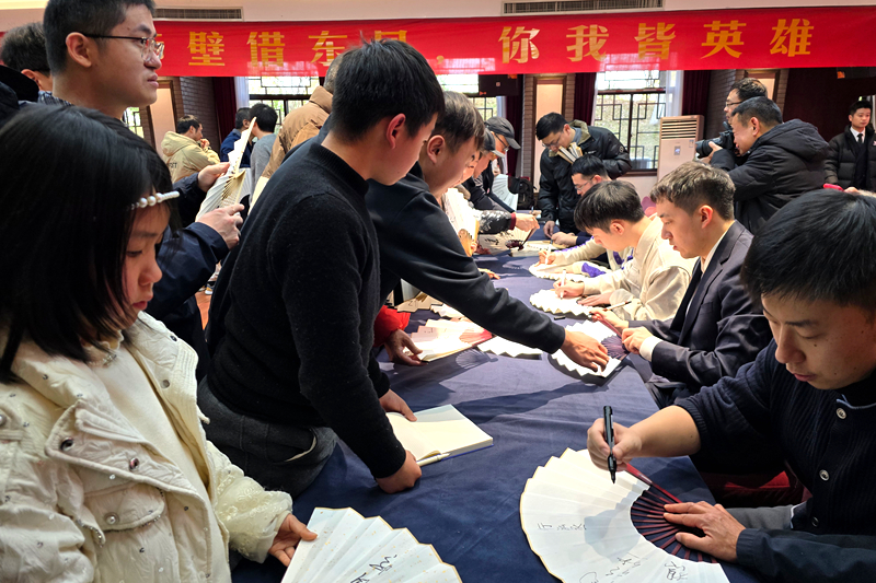 指导棋活动嘉宾为围棋爱好者签名。