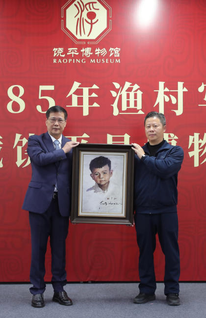饶平县县长杨镇荣（右）接收冯少协（左）捐赠作品。主办方供图