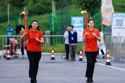 奥运冠军杨秀丽（左）、王娇传递火炬。 图片来源：活动主办方供图
