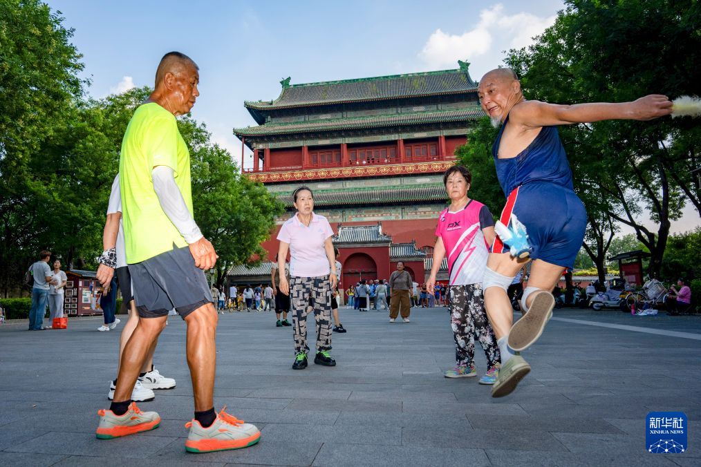 7月27日，市民在钟鼓楼广场踢毽子。