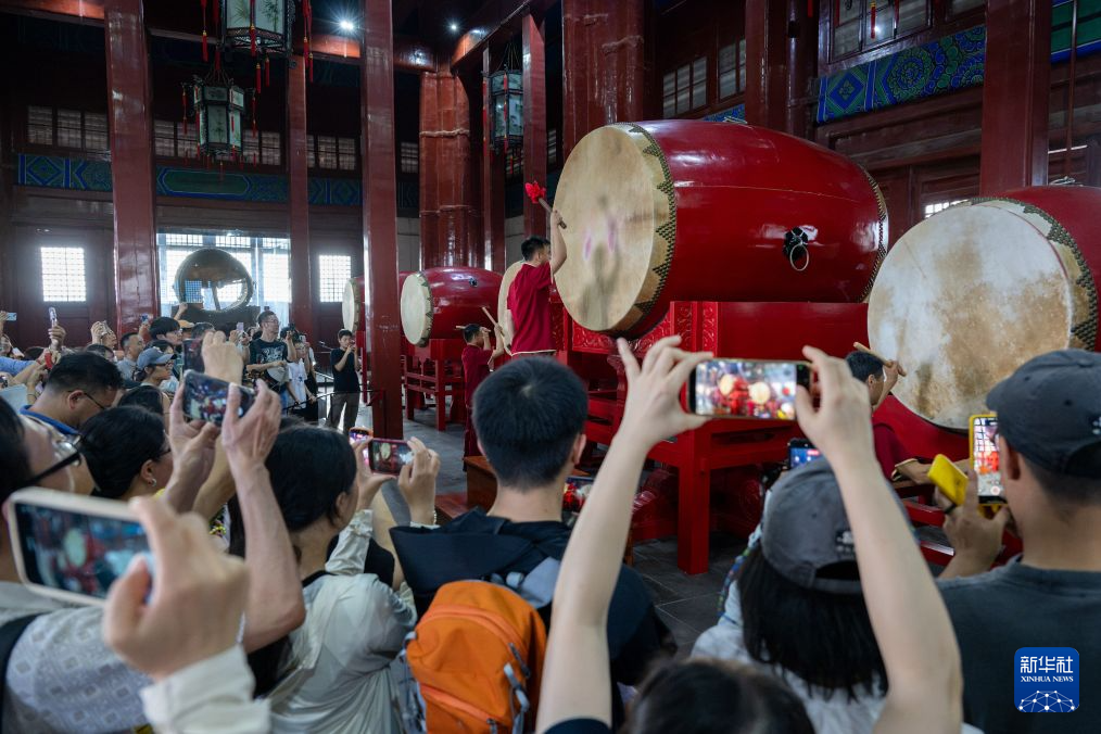7月27日，游客在北京鼓楼观看表演。