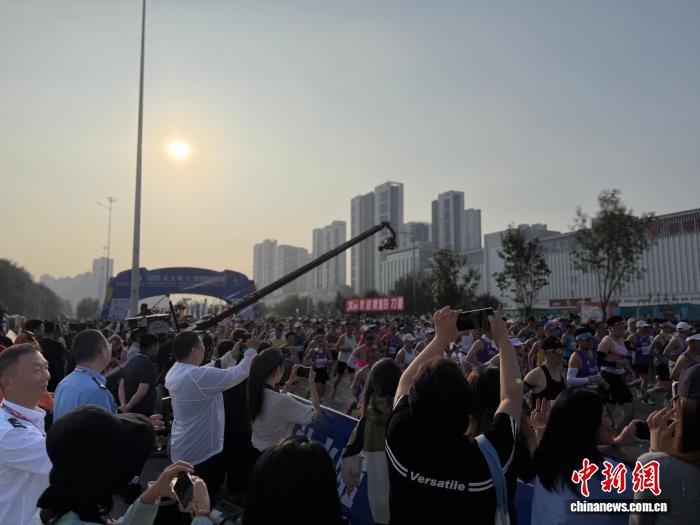 9月6日清晨7时,2026沈阳马拉松鸣枪起跑。22000名跑者齐聚沈阳奥体中心南门,迎着初秋晨光,驰骋于浑河两岸,以奔跑拥抱沈城秋日。赛事吸引了人们在赛道旁拍照。胡文熙 摄