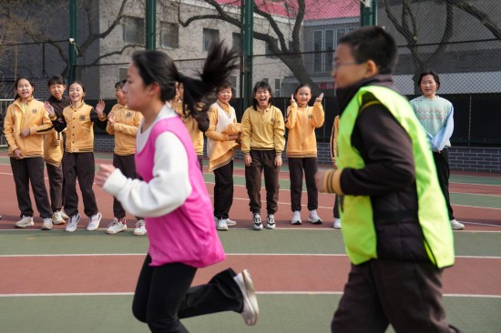 3月5日，在北京第二实验小学，学生们为参加班级赛的同学加油助威。新华社记者 鞠焕宗 摄