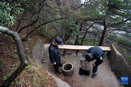 2025年4月22日，在封闭轮休中的莲花峰景点，黄山风景区管理委员会园林局护林防火队员查看防火水池蓄水情况。