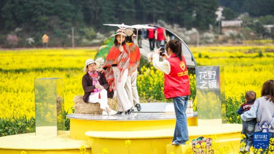 3月13日，志愿者在贵州省贵定县盘江镇“金海雪山”景区内帮助游客拍照。