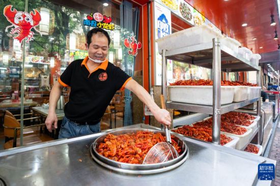 5月15日，在湖南南县沿湖路一家餐饮店，厨师烹饪小龙虾。